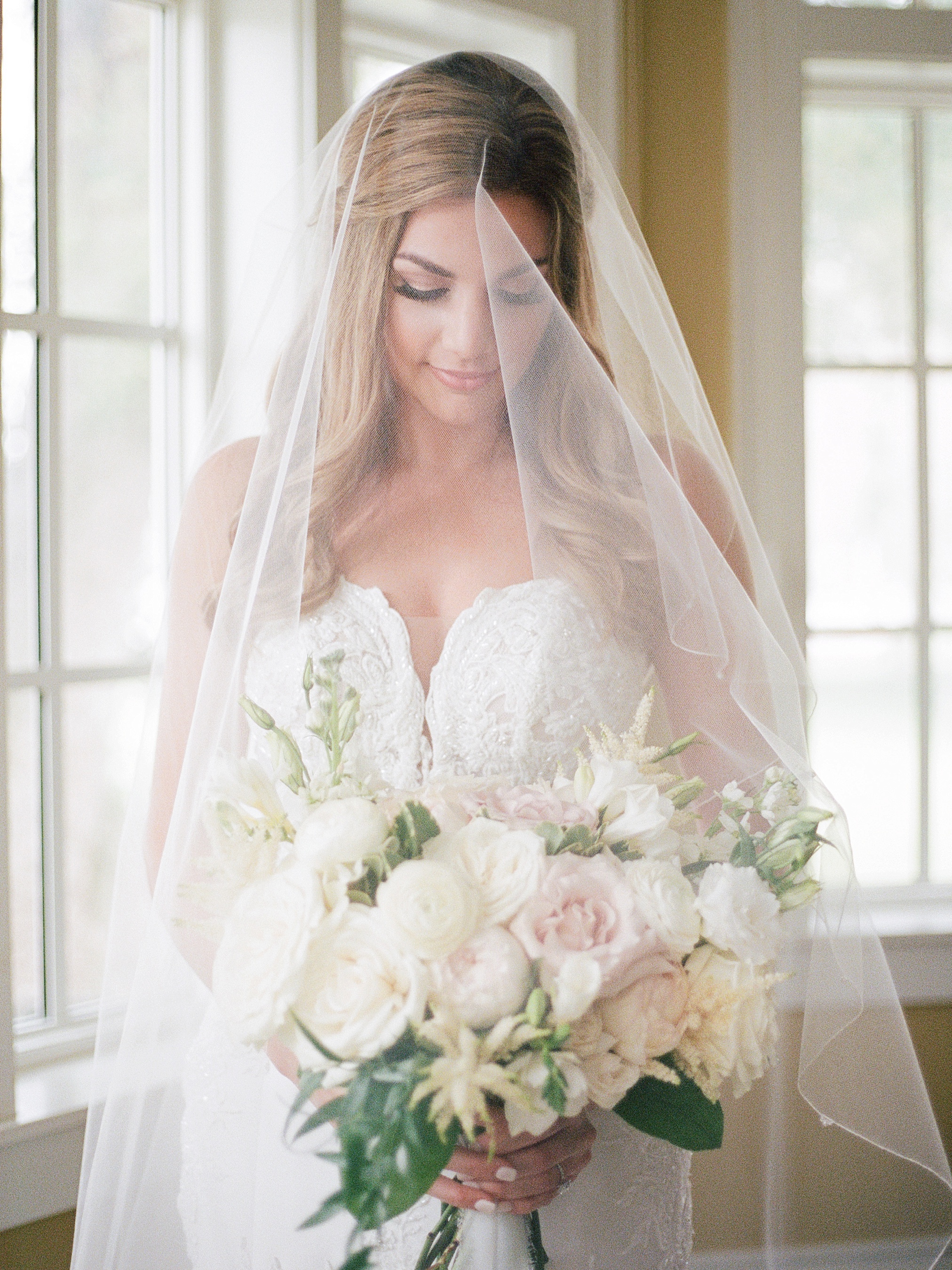 Beautiful photo of bride with veil and wedding bouquet in the bridal suite at Palmetto Riverside Bed and Breakfast 